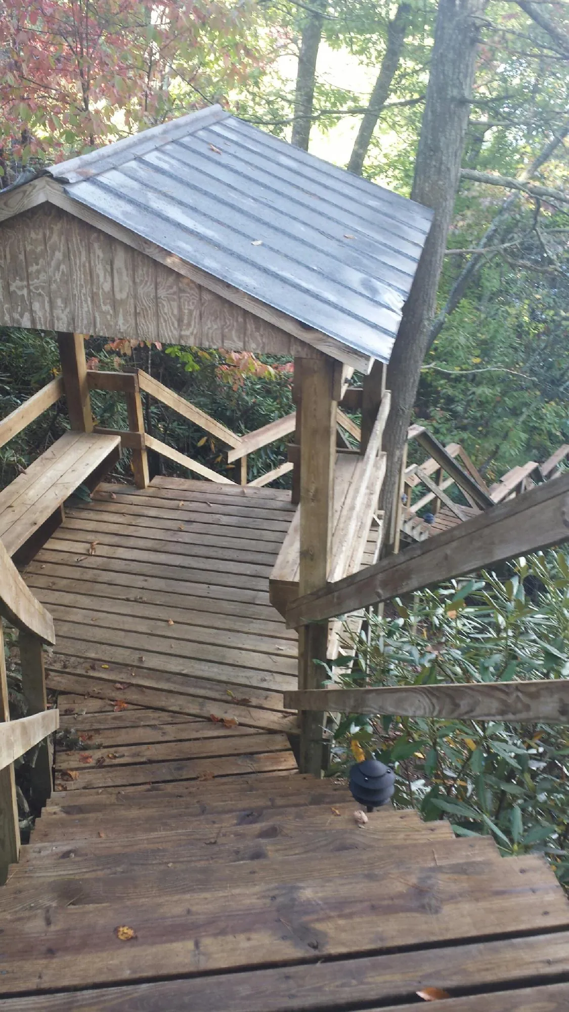 Metal roofed shelter over wooden steps on a wooded walkway — Skylight Repair & Installation work by our crew in Mount Carmel